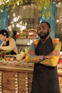 Portrait of young man standing at market