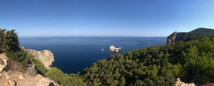 High angle view of sea and mountains against blue sky