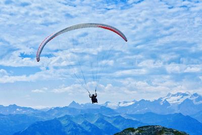 Person paragliding against sky