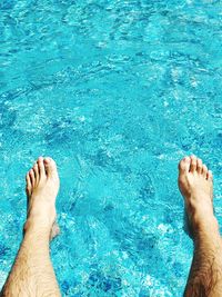 Low section of man legs in swimming pool