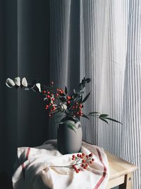 Flower vase on table against wall at home