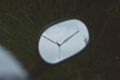 Wind turbines on field against sky