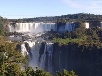 Scenic view of waterfall against sky