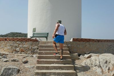 Rear view of man standing on steps