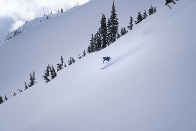Low angle view of person skiing on snowcapped mountain against sky