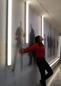 Side view of woman standing in glass