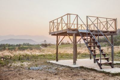 Abandoned bridge on field against sky