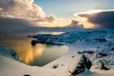 Scenic view of snow covered land against sky during sunset