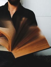 Close-up of man reading book on table