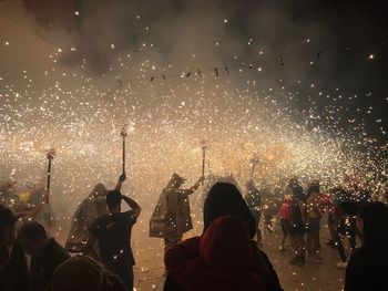 Crowd with firework display at night