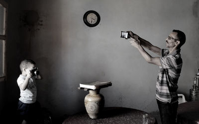 Father and son photographing at home