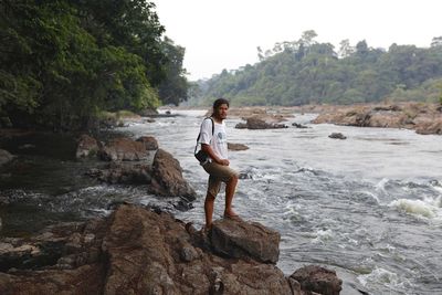 Man standing on rocks by river