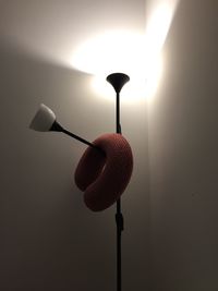 Low angle view of light bulb against wall