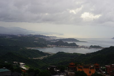 High angle view of townscape by sea against sky