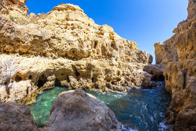 Scenic view of rocks in sea against sky