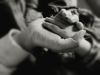 Close-up of mother holding baby hand