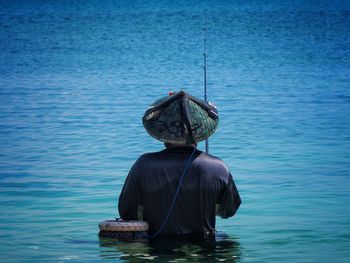 Rear view of man fishing in lake