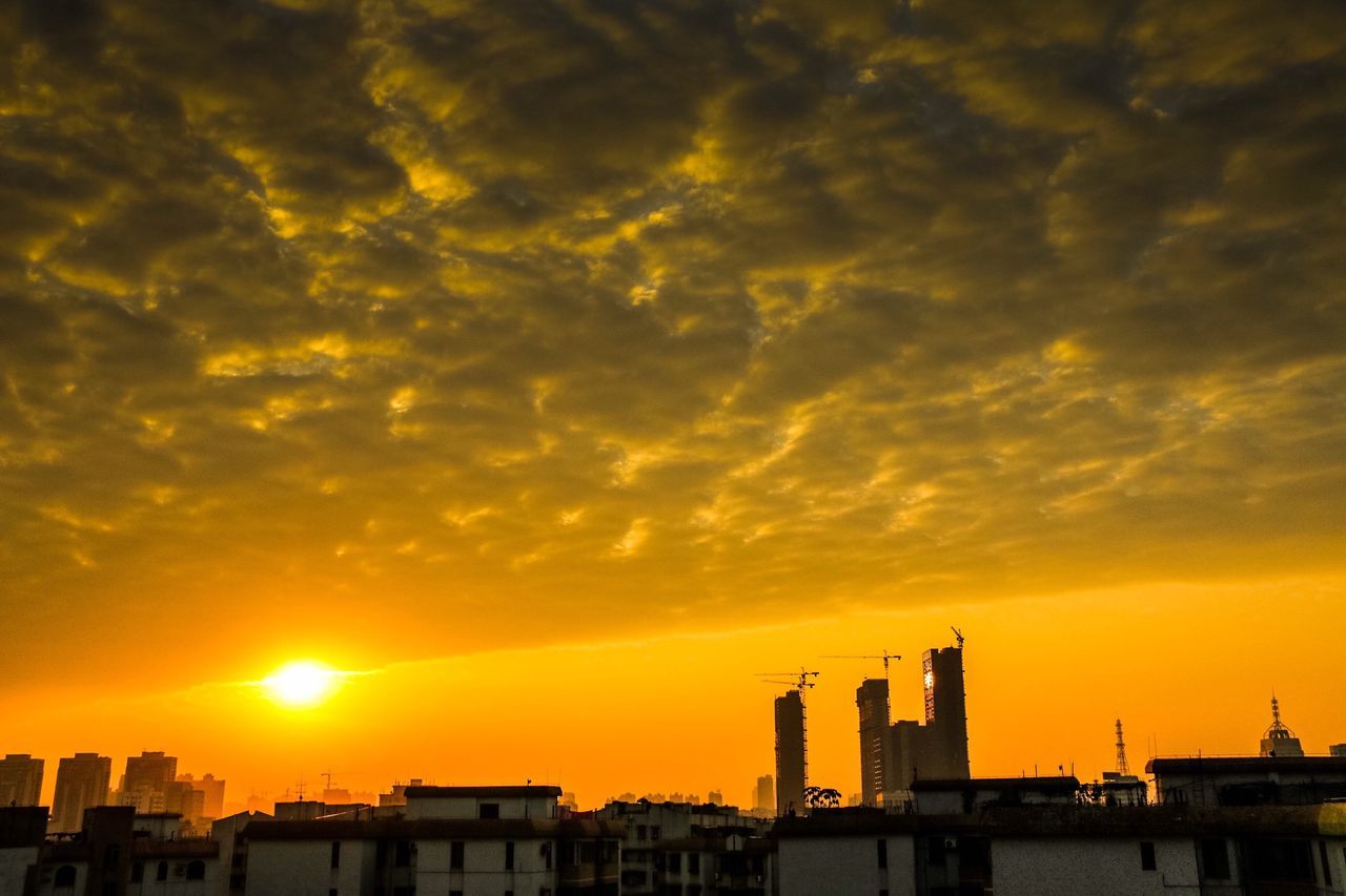 sunset, architecture, building exterior, orange color, built structure, sky, silhouette, cloud - sky, city, sun, cloud, dramatic sky, building, beauty in nature, cityscape, scenics, cloudy, nature, sunlight, outdoors