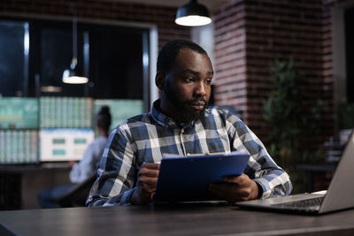 Young man using laptop while sitting on table