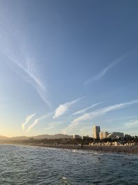 Scenic view of sea by buildings against sky