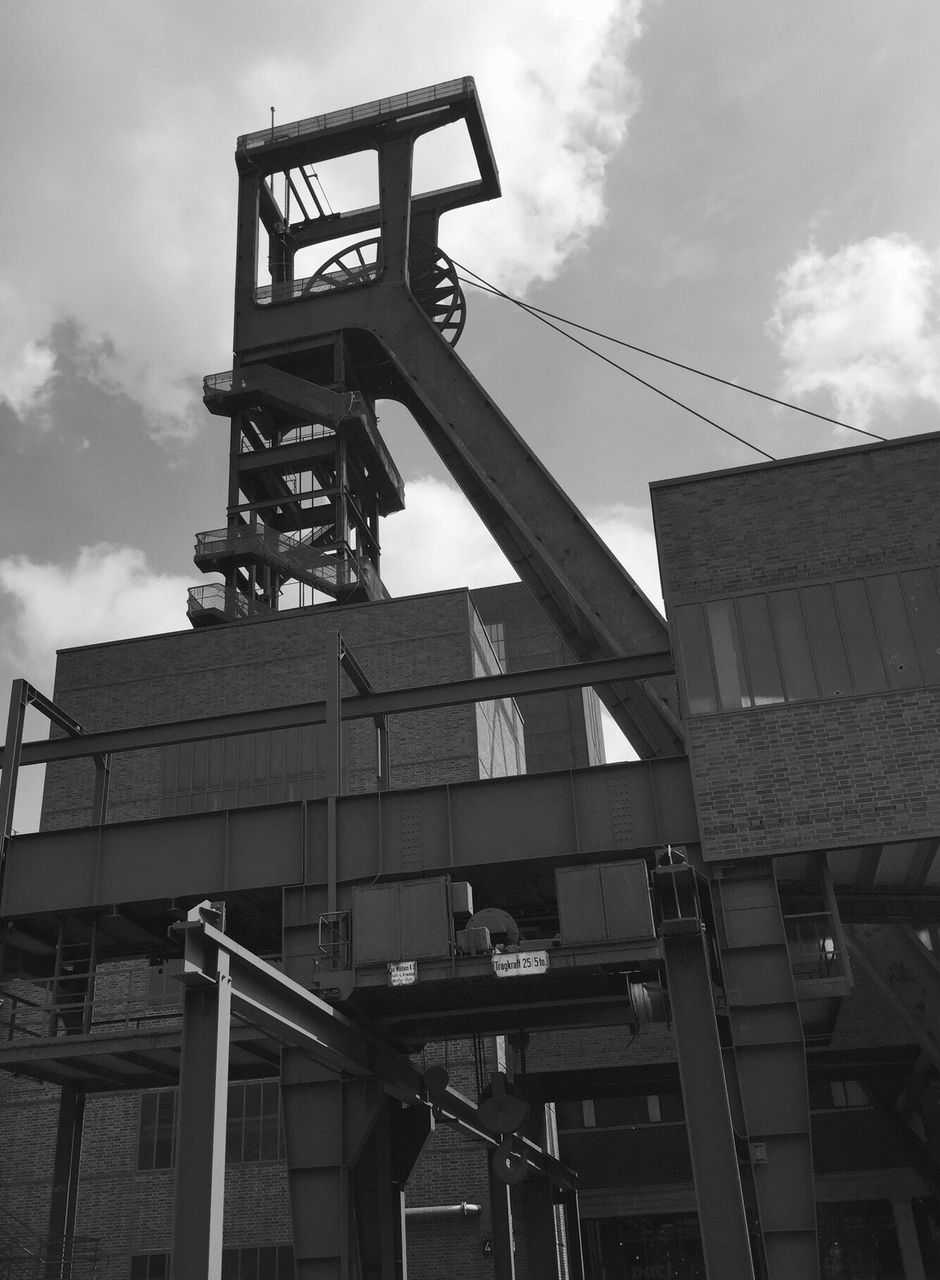 low angle view, built structure, architecture, building exterior, sky, cloud - sky, safety, outdoors, day, industry, manual worker, people