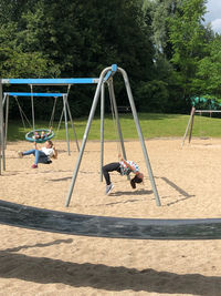 Children playing on swing at playground