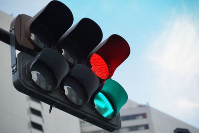 Low angle view of road signal against sky