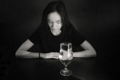Close-up of woman holding drink in glass on table