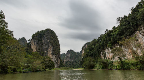 Scenic view of rock formation by trees against sky