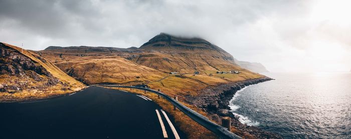 Panoramic view of road by sea against sky