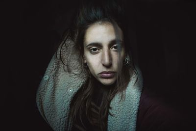 Close-up portrait of young woman in darkroom