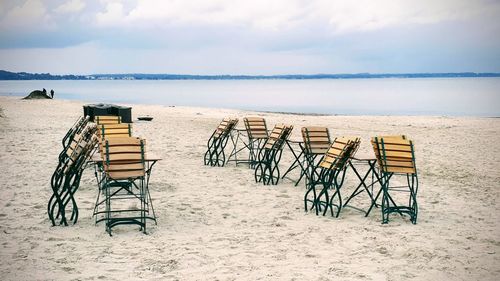 View of chairs on beach against sky