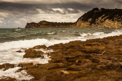 Scenic view of rocks on beach against sky