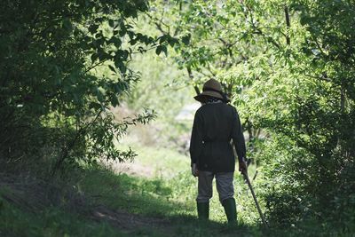 Rear view of person walking in farm