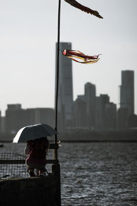 Man in sea against sky in city