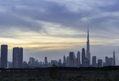 View of buildings against cloudy sky during sunset