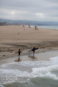 Scenic view of beach against cloudy sky