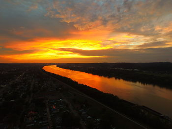 Scenic view of lake against cloudy sky during sunset