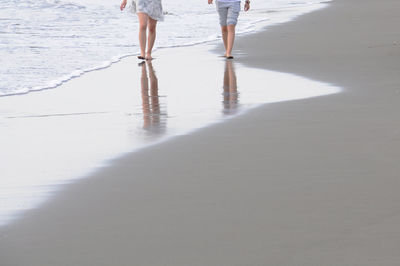 A couple walking on the beach.