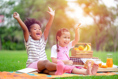 Mother and smiling girl sitting outdoors