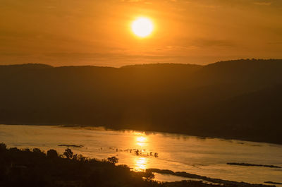 Scenic view of silhouette trees against orange sky