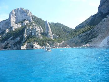 Boat in river against mountains during sunny day