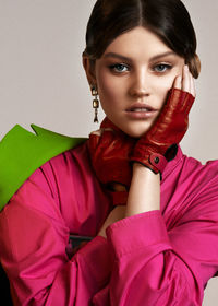 Portrait of young woman against wall