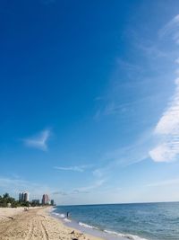 Scenic view of beach against blue sky