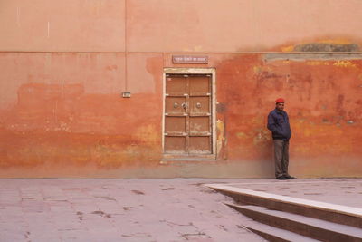 Rear view of man standing against wall