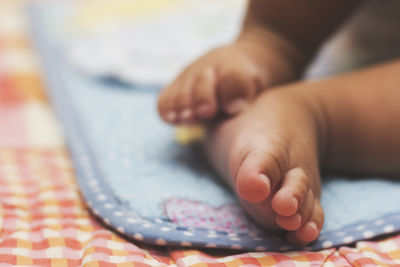 Close-up of baby hand on bed