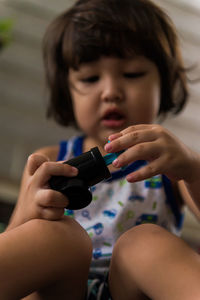 Close-up of boy looking away while sitting indoor