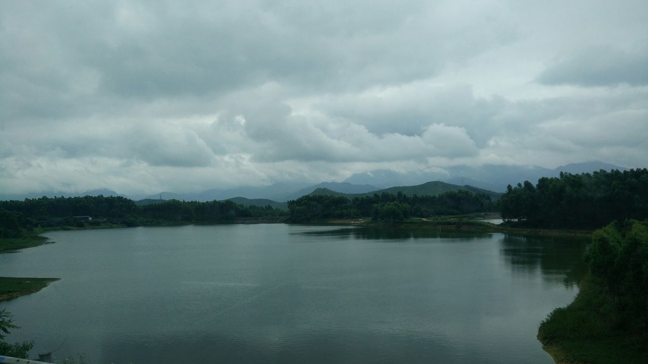 water, sky, tranquil scene, tranquility, lake, scenics, cloud - sky, beauty in nature, cloudy, tree, waterfront, nature, reflection, cloud, river, idyllic, mountain, calm, outdoors, non-urban scene