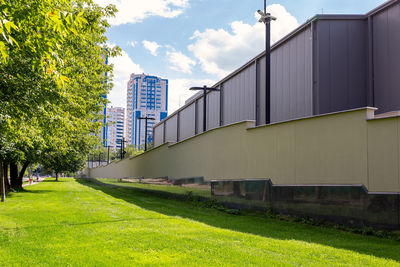 Scenic view of field by buildings against sky