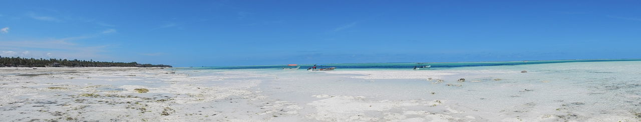 Scenic view of beach against blue sky